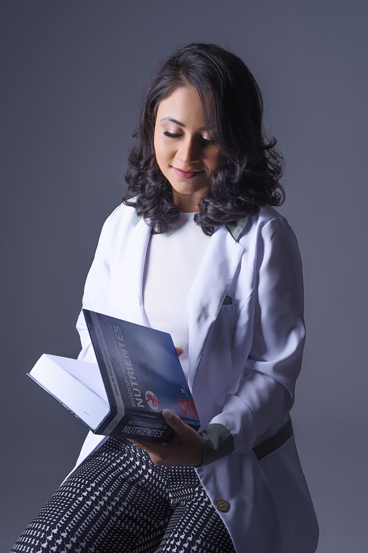 Daniela Ramos lendo um livro sobre biodisponibilidade de nutrientes